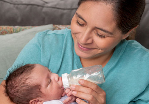 Carga al bebé de manera que su cabecita esté un poco más elevada que el resto del cuerpo.