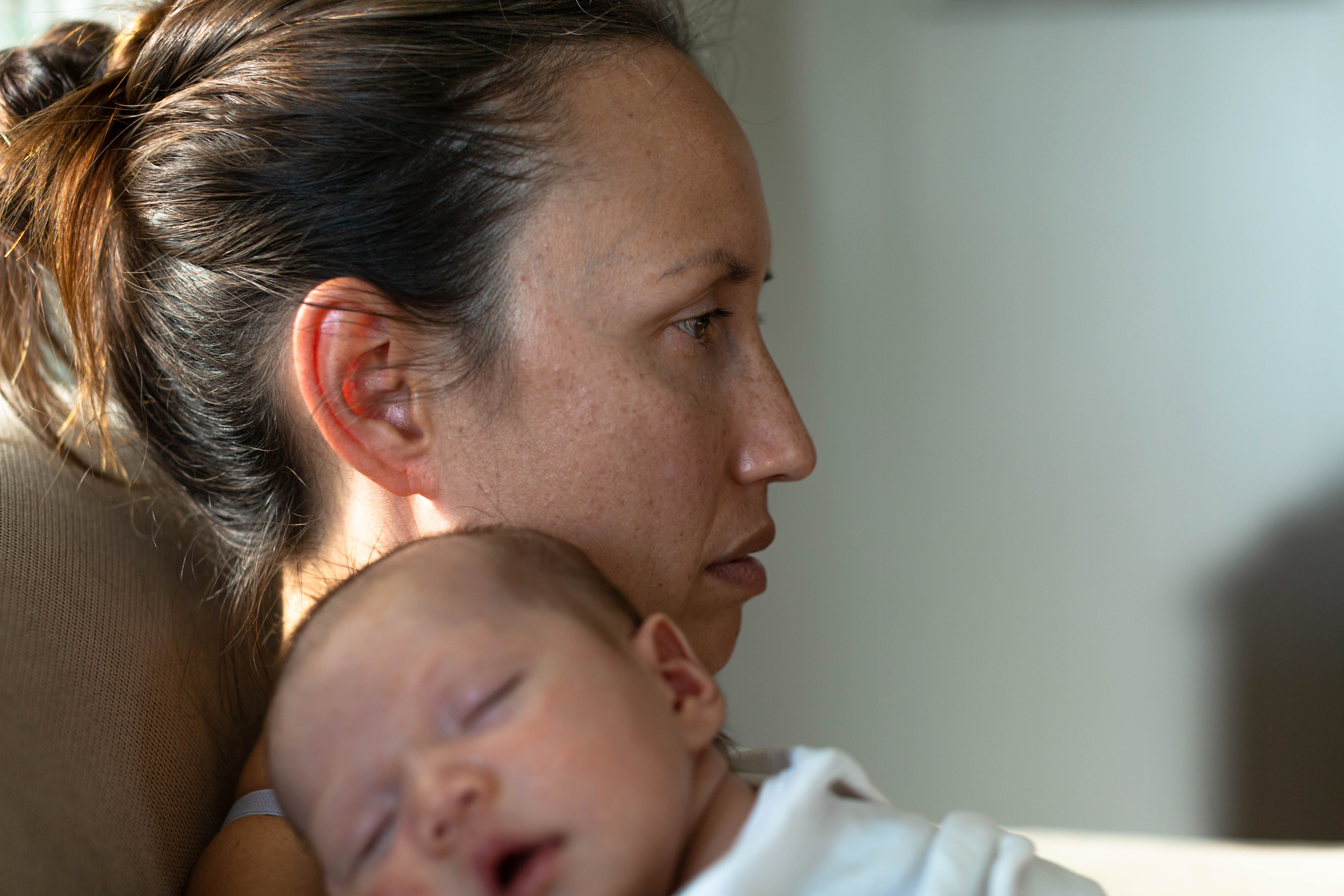 A mother holding her baby dealing with postpartum depression